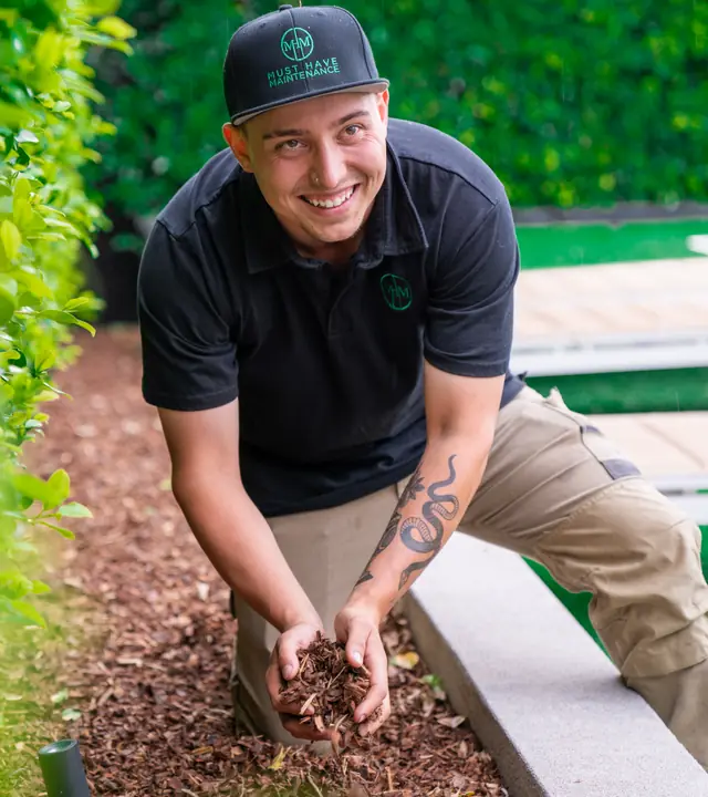 Fresh mulch being laid in a garden bed